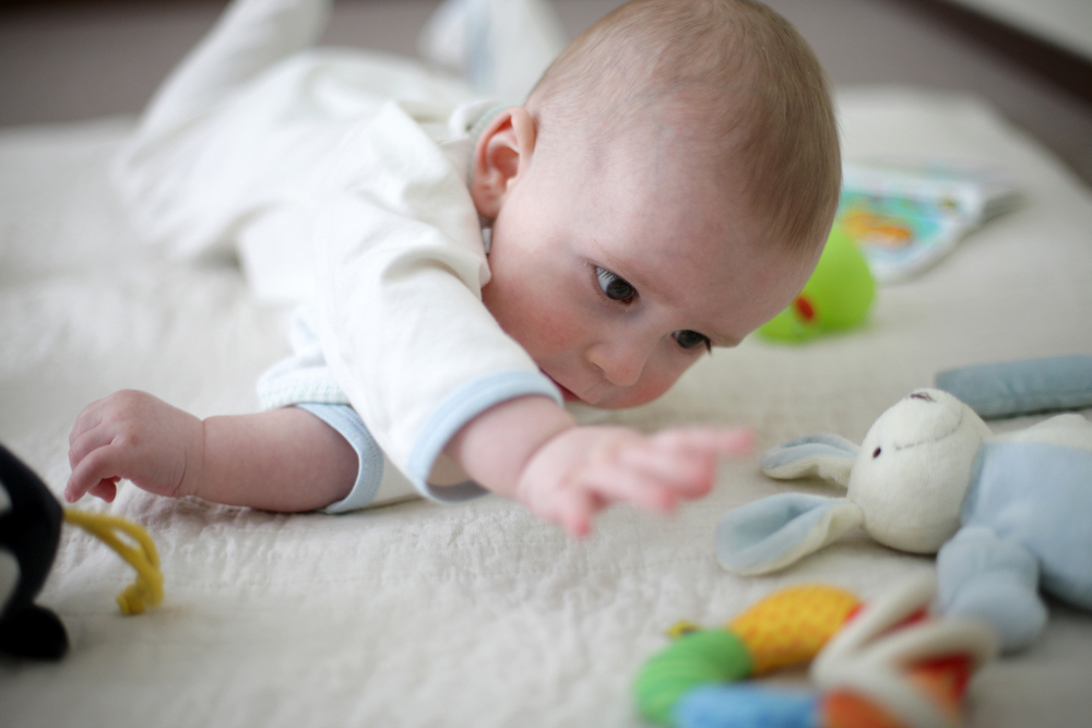 Baby reikt naar speeltje